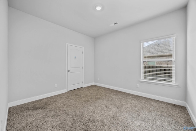 unfurnished room featuring carpet floors and baseboards