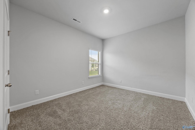 spare room with baseboards, carpet flooring, and visible vents