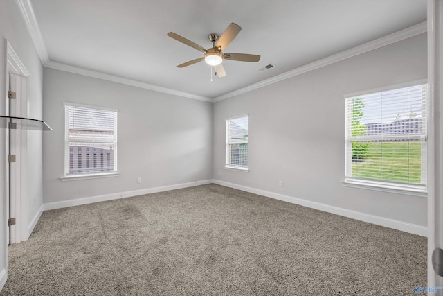 carpeted empty room with visible vents, ornamental molding, baseboards, and ceiling fan