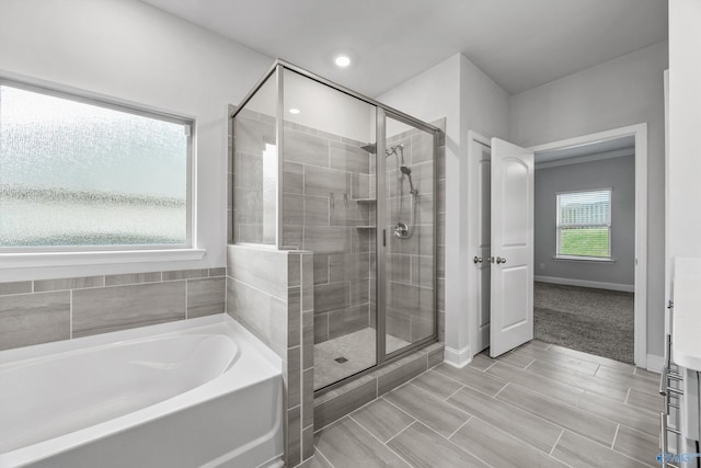 full bath with baseboards, a bath, and a shower stall