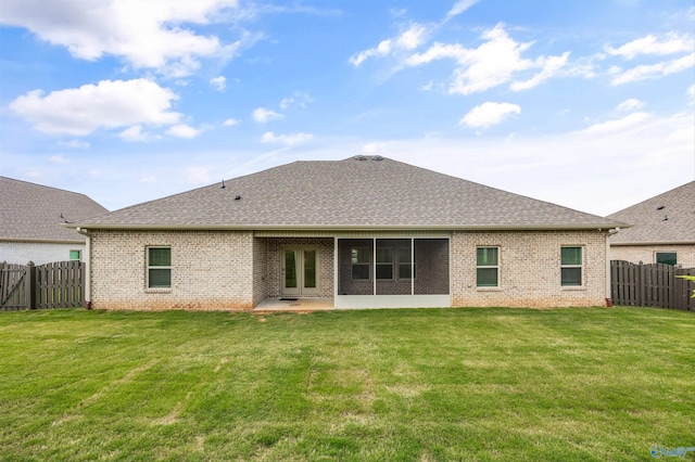 back of house featuring a fenced backyard, a shingled roof, a lawn, and brick siding
