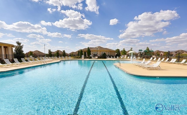 community pool with fence and a patio area