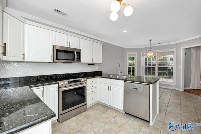 114 Canterbury Dr, Madison, AL 35758 - kitchen with appliances with stainless steel finishes, a peninsula, tasteful backsplash, light tile patterned flooring, and crown molding