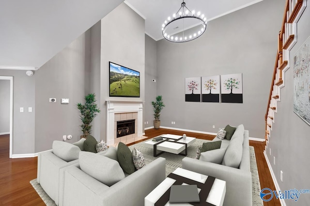 114 Canterbury Dr, Madison, AL 35758 - living room featuring wood finished floors, a chandelier, a tile fireplace, ornamental molding, and a high ceiling