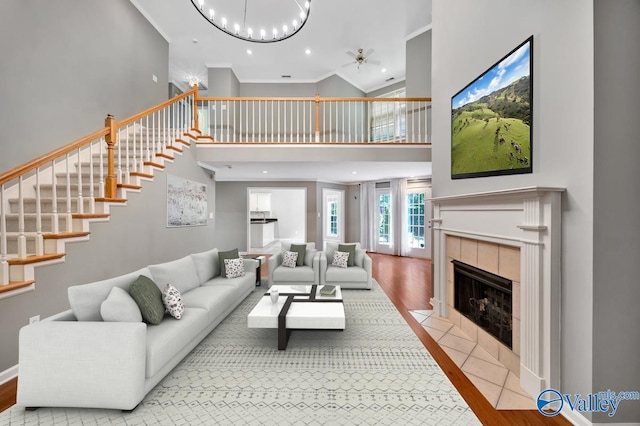 114 Canterbury Dr, Madison, AL 35758 - living room with a towering ceiling, ceiling fan, wood finished floors, a tile fireplace, and ornamental molding