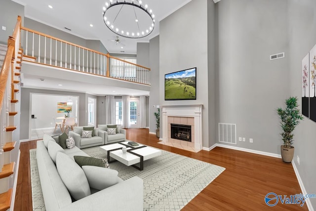 114 Canterbury Dr, Madison, AL 35758 - living area featuring a towering ceiling, a chandelier, wood finished floors, a fireplace, and stairway
