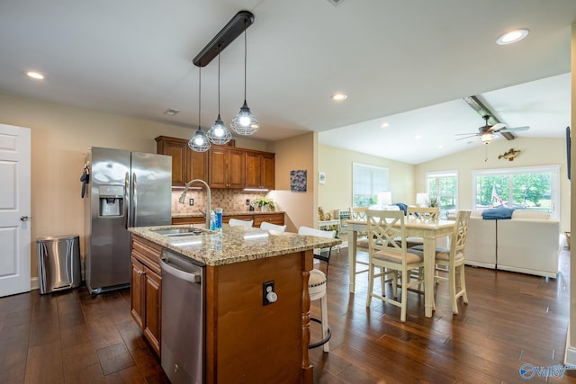 915 County Road 349, Leesburg, AL 35983 - kitchen with brown cabinets, stainless steel appliances, a ceiling fan, a sink, and light stone countertops