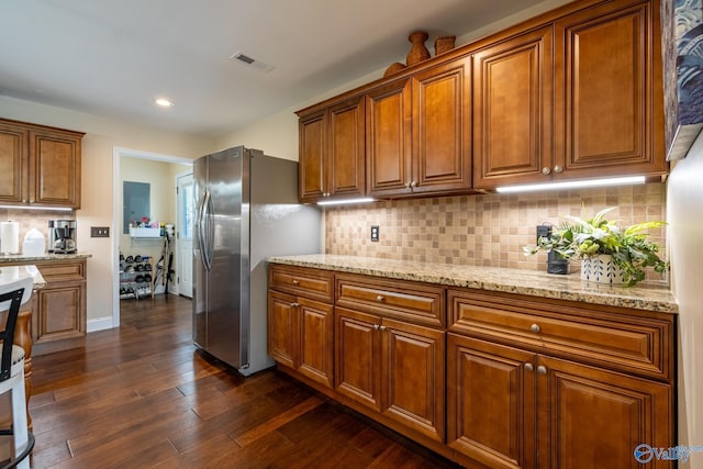915 County Road 349, Leesburg, AL 35983 - kitchen with light stone counters, brown cabinets, dark wood finished floors, stainless steel refrigerator with ice dispenser, and visible vents