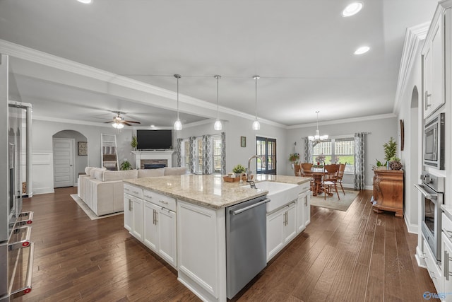 7417 Nature Walk Way SE, Owens Cross Roads, AL 35763 - kitchen with stainless steel appliances, a sink, arched walkways, a fireplace, and ceiling fan