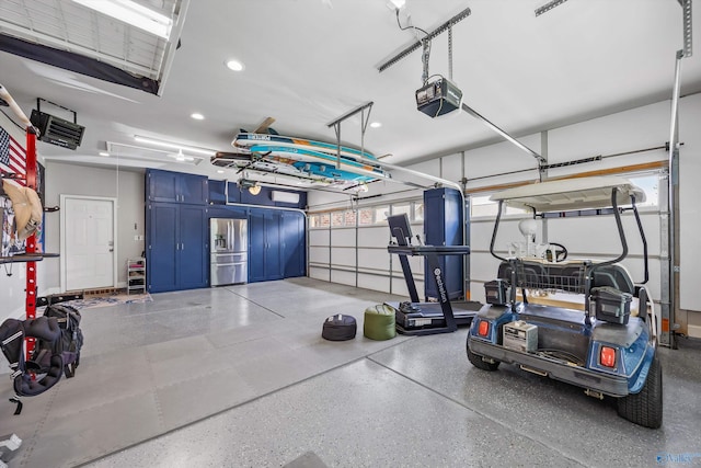7417 Nature Walk Way SE, Owens Cross Roads, AL 35763 - garage featuring stainless steel fridge, a garage door opener, and recessed lighting