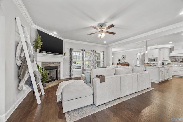 7417 Nature Walk Way SE, Owens Cross Roads, AL 35763 - living room with a fireplace, a ceiling fan, crown molding, dark wood-style floors, and recessed lighting