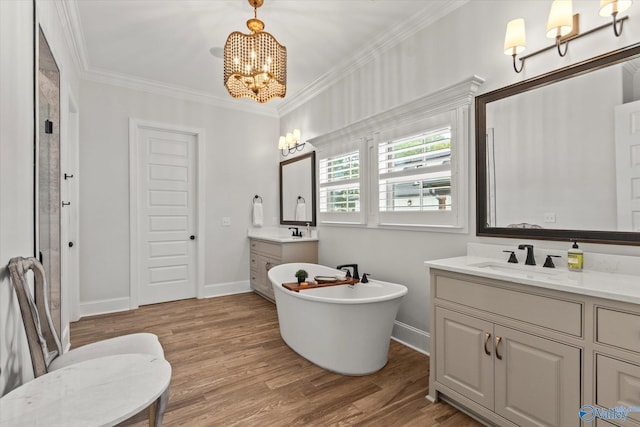 bathroom featuring ornamental molding, vanity, a bath, hardwood / wood-style flooring, and a notable chandelier