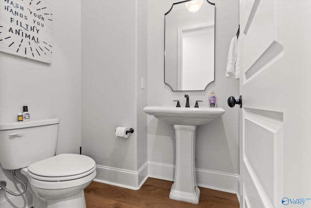 bathroom with hardwood / wood-style floors and toilet