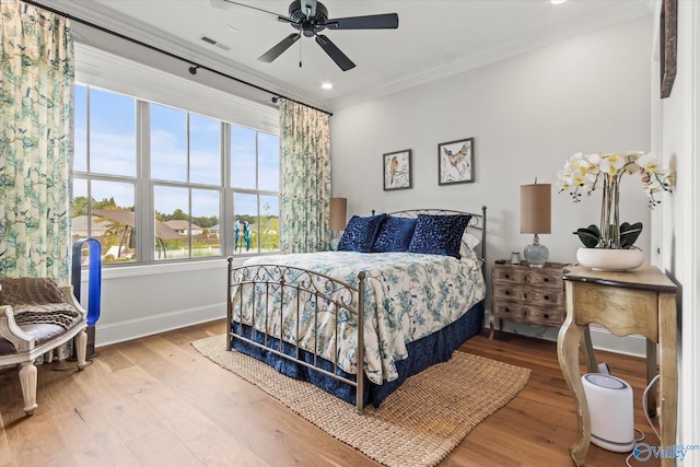 bedroom featuring hardwood / wood-style floors, ceiling fan, and ornamental molding