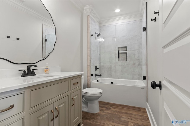 full bathroom with vanity, crown molding, wood-type flooring, toilet, and tiled shower / bath