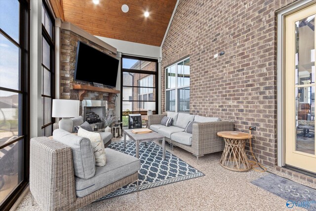 living room featuring a large fireplace, brick wall, wood ceiling, and high vaulted ceiling