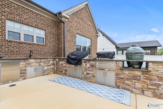 view of patio / terrace featuring an outdoor kitchen, area for grilling, and sink