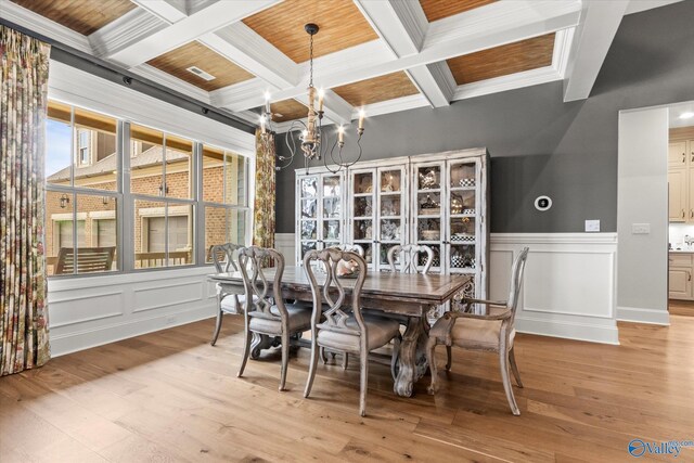 dining area with light wood-type flooring, crown molding, wooden ceiling, and a notable chandelier