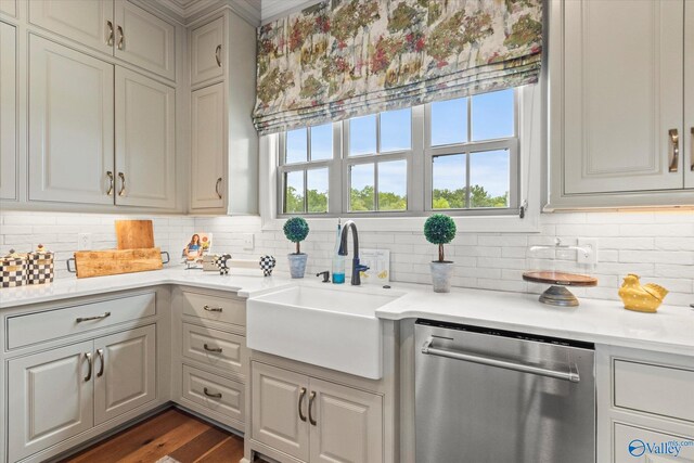 kitchen featuring sink, tasteful backsplash, dark hardwood / wood-style flooring, stainless steel dishwasher, and gray cabinets