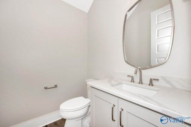 bathroom with hardwood / wood-style flooring, vanity, and toilet