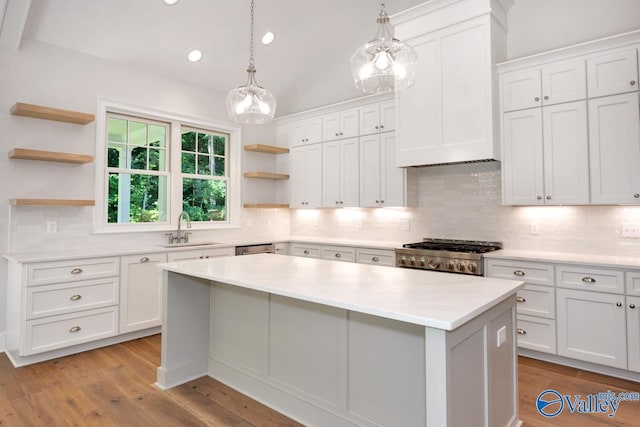 kitchen with white cabinetry, sink, and range