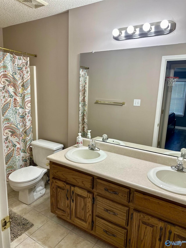 bathroom featuring vanity, a textured ceiling, tile patterned floors, and toilet