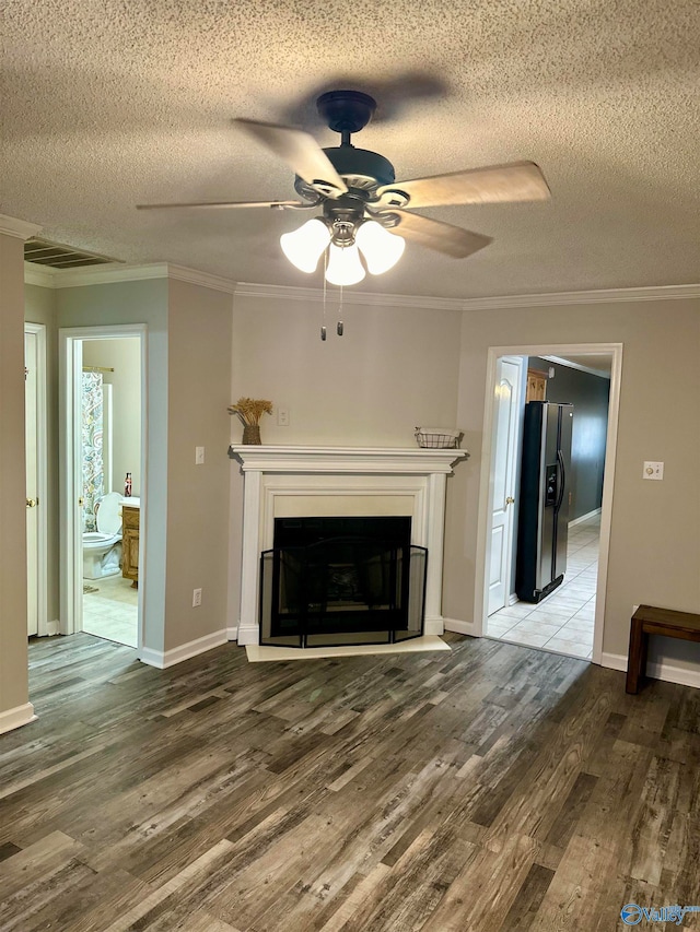 unfurnished living room with crown molding, ceiling fan, wood-type flooring, and a textured ceiling