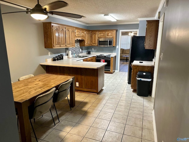 kitchen with kitchen peninsula, a kitchen breakfast bar, black range, and crown molding