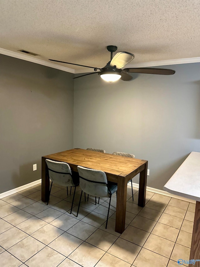 dining space with crown molding, ceiling fan, light tile patterned flooring, and a textured ceiling