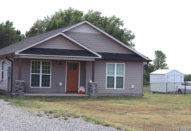 view of front of house featuring a storage unit, a front lawn, and a porch