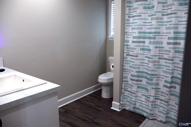 bathroom with vanity, toilet, hardwood / wood-style floors, and curtained shower