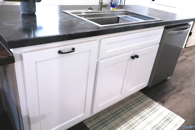 kitchen featuring dishwasher, dark wood-type flooring, sink, and white cabinets