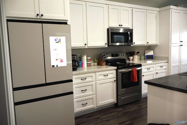 kitchen with appliances with stainless steel finishes, dark hardwood / wood-style flooring, and white cabinetry