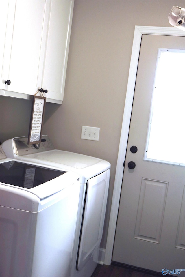 clothes washing area with cabinets and washer and clothes dryer