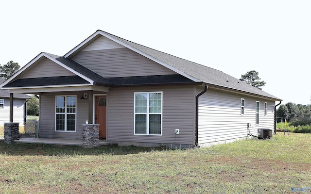 rear view of house with a lawn, a patio, and cooling unit