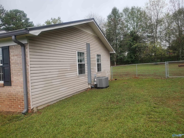 view of property exterior featuring central air condition unit and a yard