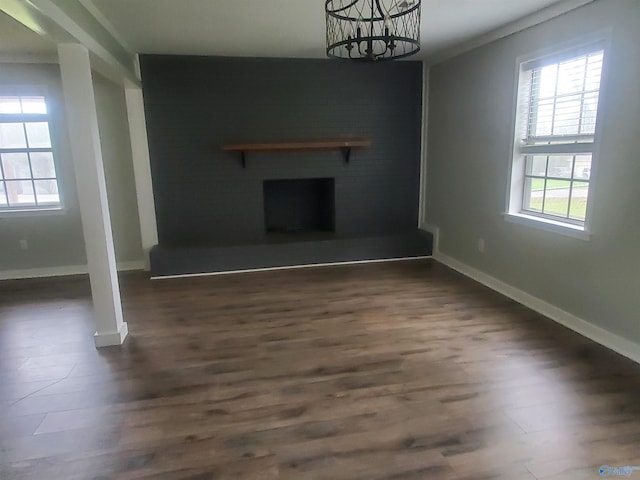 unfurnished living room featuring dark hardwood / wood-style flooring and a notable chandelier