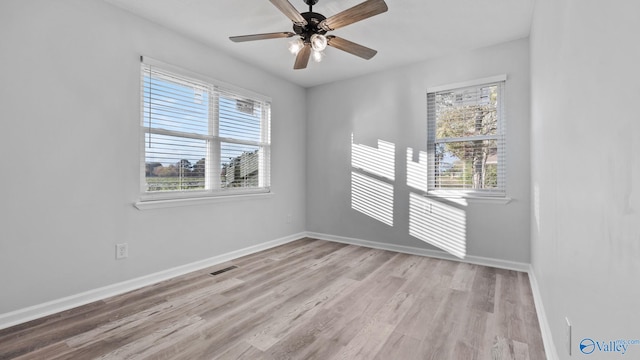 empty room with ceiling fan and light hardwood / wood-style floors