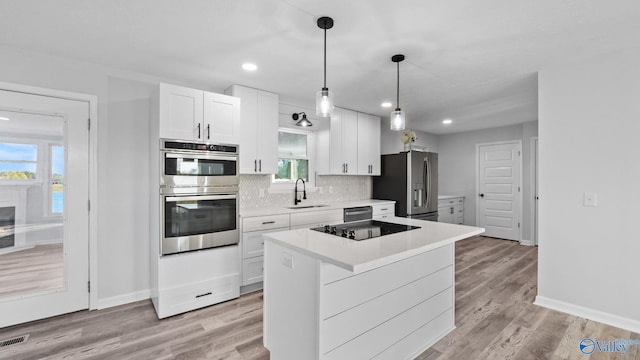 kitchen featuring light hardwood / wood-style floors, white cabinetry, sink, and appliances with stainless steel finishes