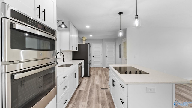 2055 Big Nose Dr, Centre, AL 35960 - kitchen featuring a sink, appliances with stainless steel finishes, a center island, white cabinets, and light wood finished floors