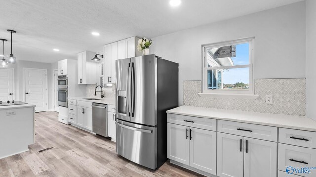2055 Big Nose Dr, Centre, AL 35960 - kitchen with stainless steel appliances, a sink, white cabinetry, light countertops, and decorative light fixtures