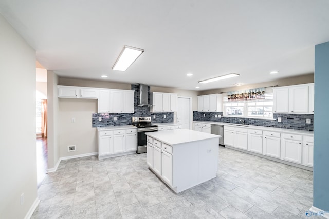 kitchen featuring wall chimney exhaust hood, a kitchen island, white cabinetry, and stainless steel appliances