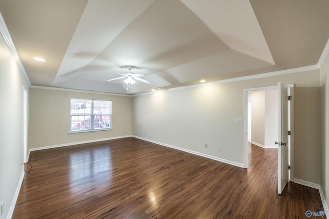 spare room with dark hardwood / wood-style floors, ceiling fan, ornamental molding, and a tray ceiling