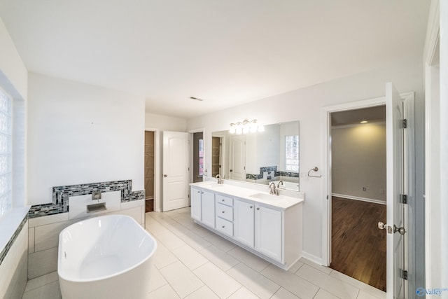 bathroom featuring a bathing tub, tile patterned flooring, vanity, and tile walls