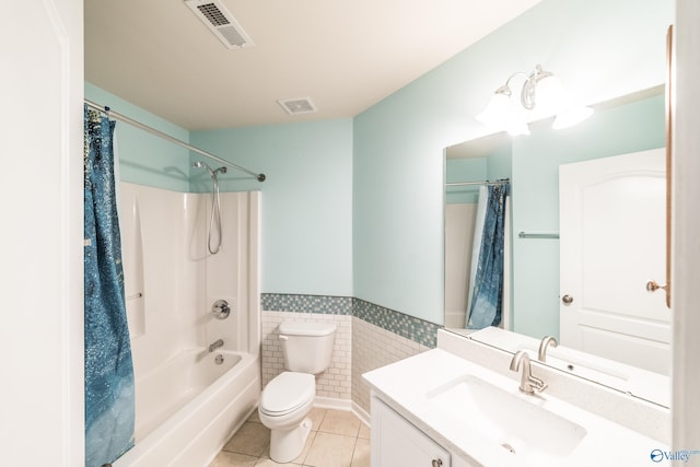 full bathroom with tile patterned floors, toilet, shower / tub combo with curtain, vanity, and tile walls