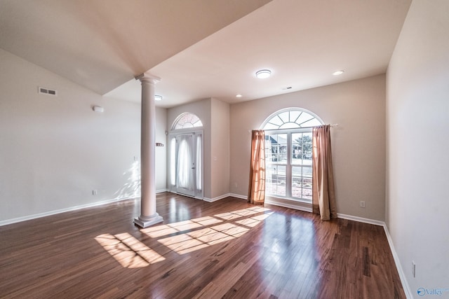 interior space featuring decorative columns and dark wood-type flooring