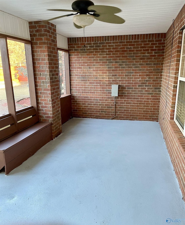 unfurnished sunroom with ceiling fan