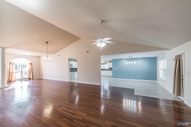 unfurnished living room with ceiling fan with notable chandelier, dark hardwood / wood-style floors, high vaulted ceiling, and a wealth of natural light