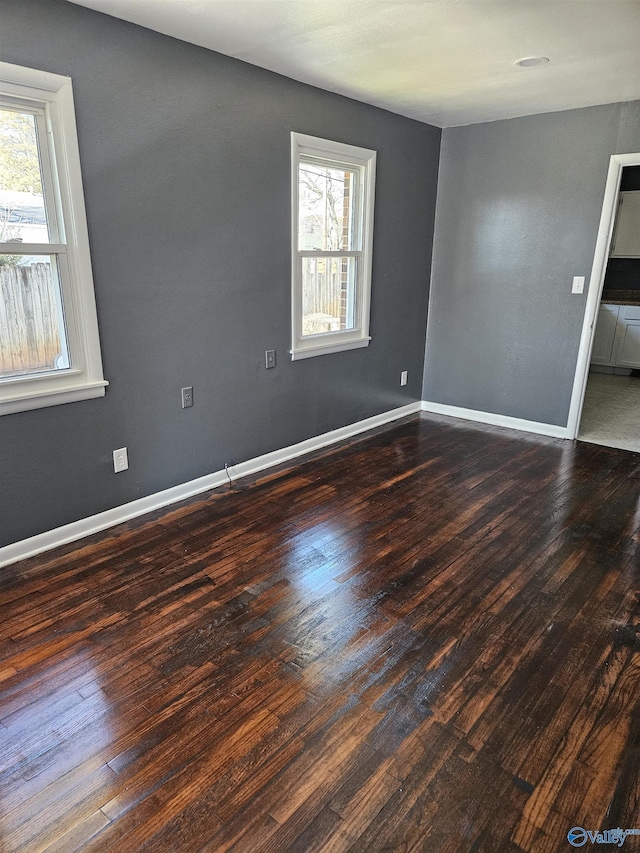 empty room with dark wood-type flooring and a healthy amount of sunlight