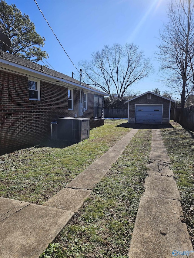 view of yard featuring a garage, an outdoor structure, and central air condition unit